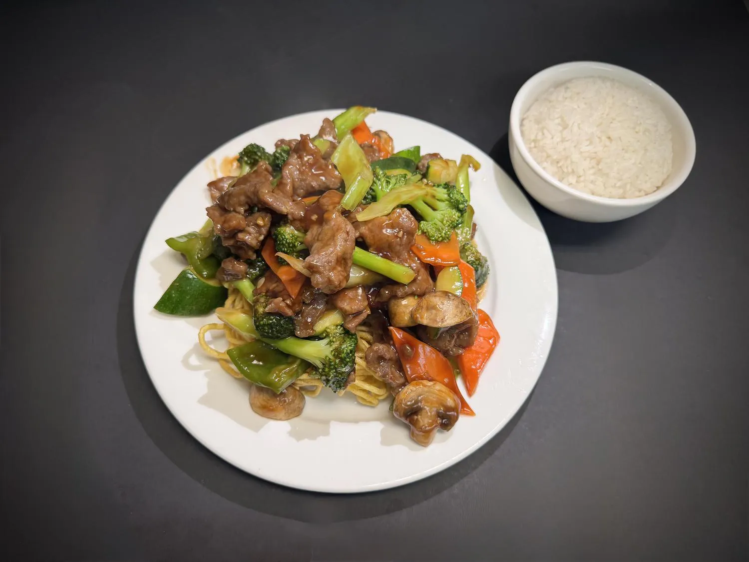 Beef stir‑fry with mixed vegetables over crispy noodles, side steamed rice at Lucky House, a Chinese restaurant in Surprise Beef stir‑fry with mixed vegetables over crispy noodles, side steamed rice at Lucky House, a Chinese restaurant in Surprise