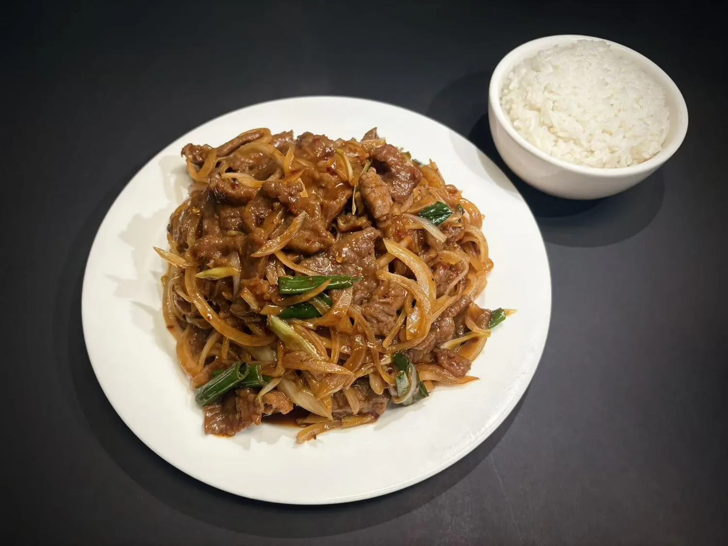 Stir‑fried beef with onions and green scallions, served with steamed white rice at Lucky House, a Chinese restaurant in Surprise Stir‑fried beef with onions and green scallions, served with steamed white rice at Lucky House, a Chinese restaurant in Surprise