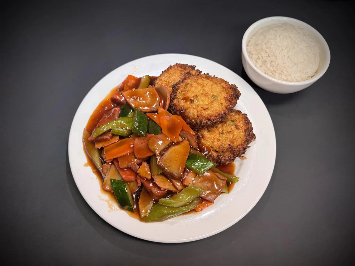 Mixed vegetable stir‑fry paired with crispy pan‑fried patties and steamed rice at Lucky House, a Chinese restaurant in Surprise Mixed vegetable stir‑fry paired with crispy pan‑fried patties and steamed rice at Lucky House, a Chinese restaurant in Surprise